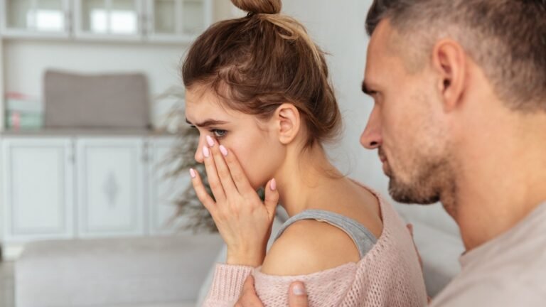 a crying woman and man behind her