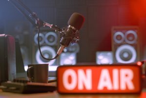Radio broadcasting station professional equipment and On Air light sign in the foreground